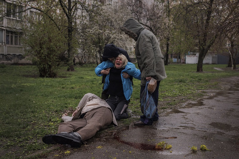 Яна Бачек плаче над тілом батька, який пішов за хлібом і загинув під обстрілом. Фото: Алкіс Константінідіс