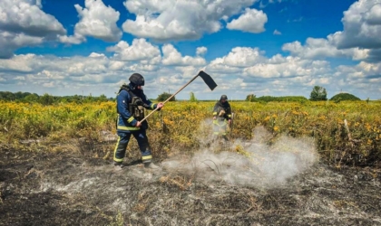 Обстріли Харківщини: у трьох районах горіли поля, в Богодухові постраждали троє людей Рятувальник гасить пожежу в полі на Харківщині