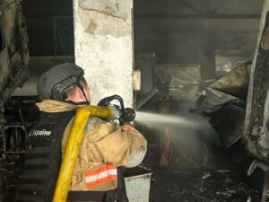 Рятувальник гасить пожежу від удару дрона в Дергачах, 14 жовтня 2026